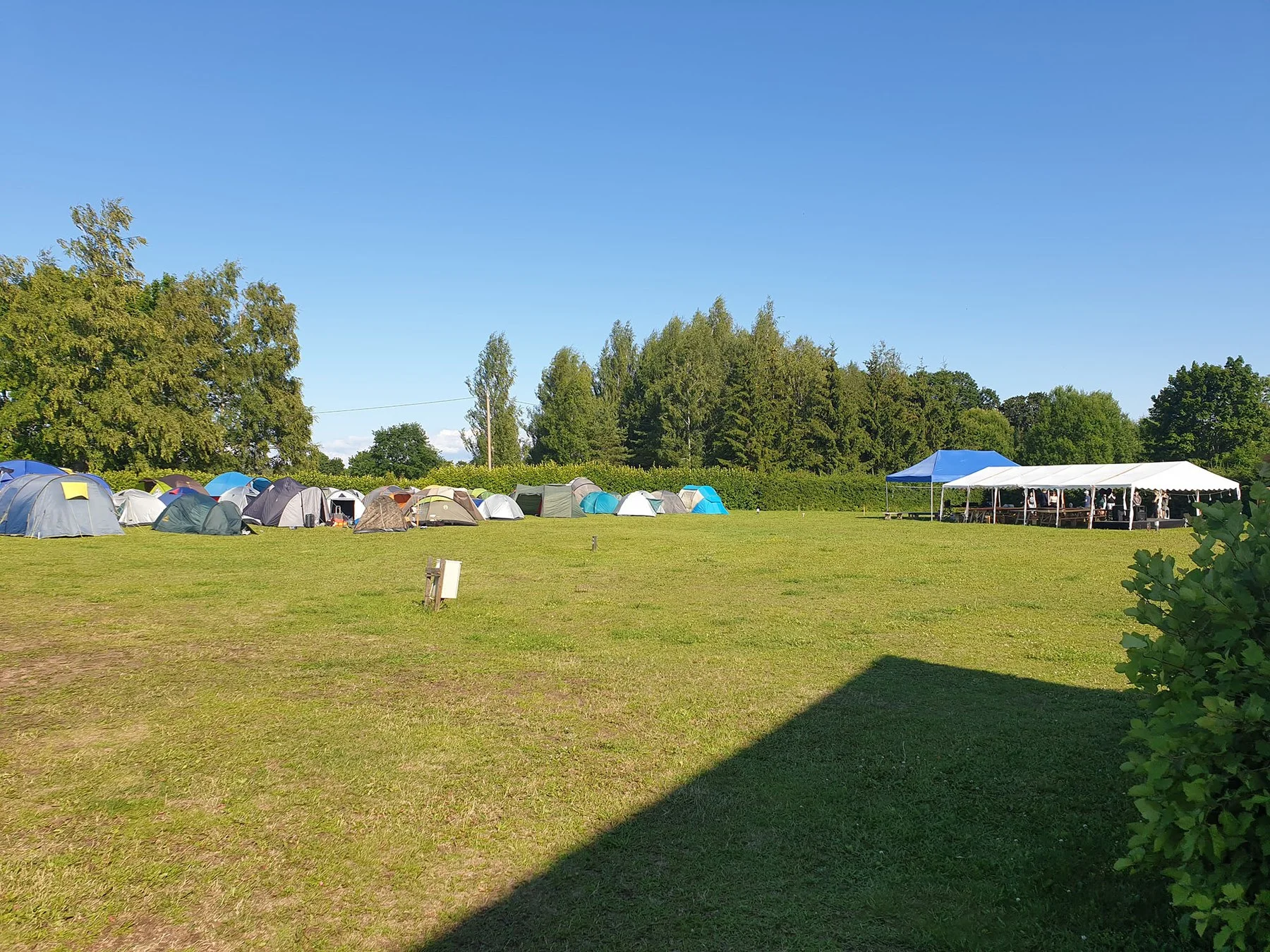 Camping area with a white party tent on a summer day