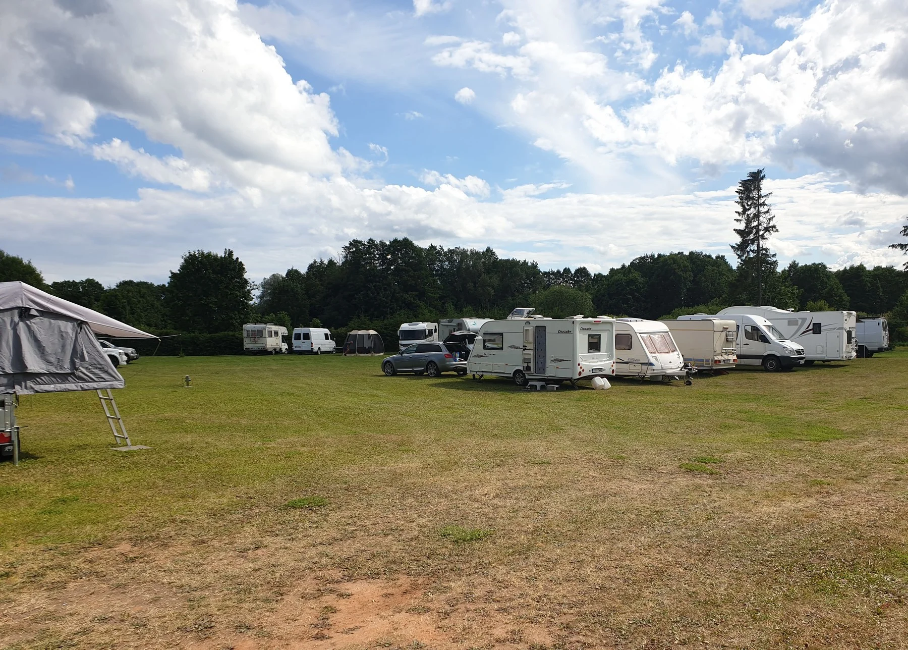 Caravans on a wide lawn under a cloudy sky