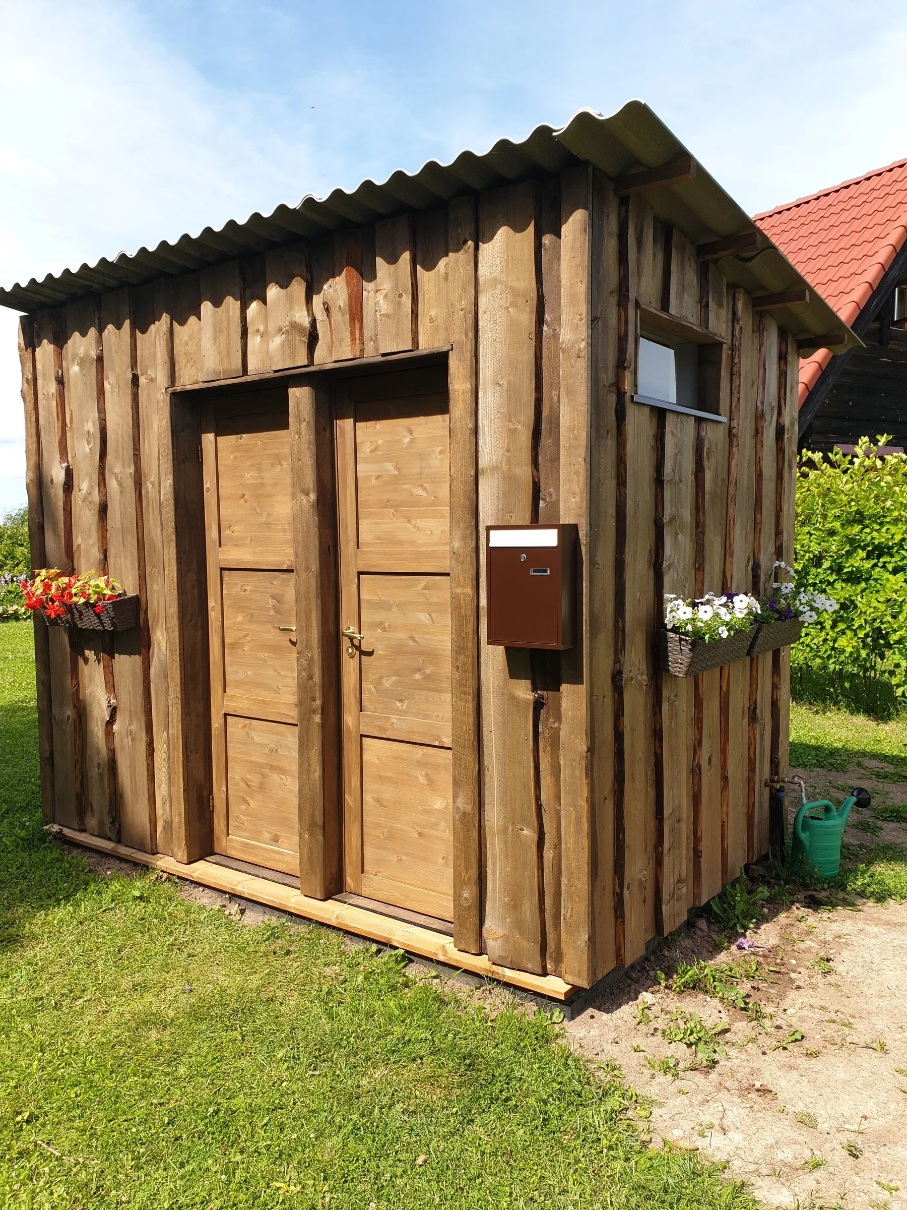 WC and shower doors of the log building with flower boxes