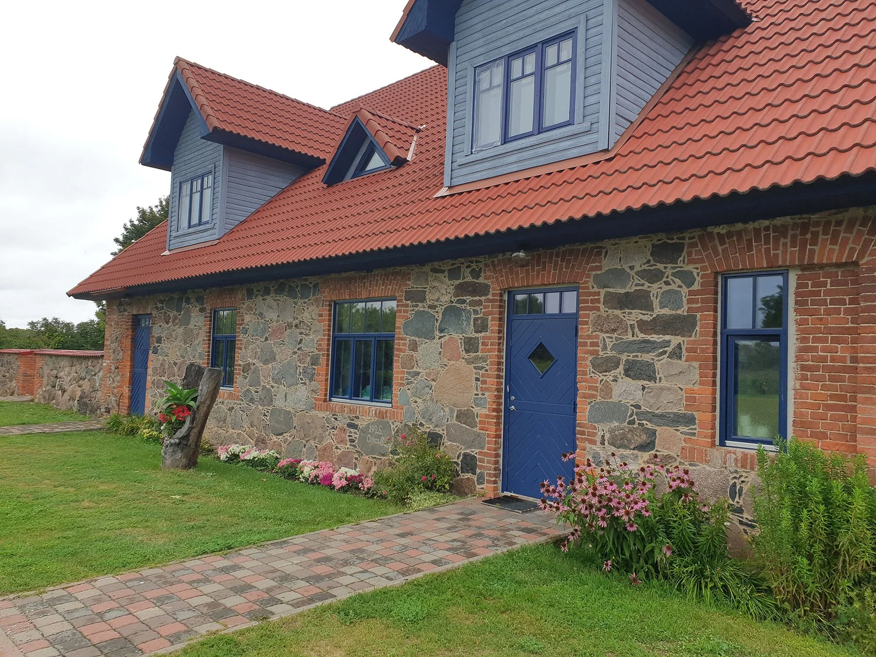 Blue door of the holiday house and a flower bed
