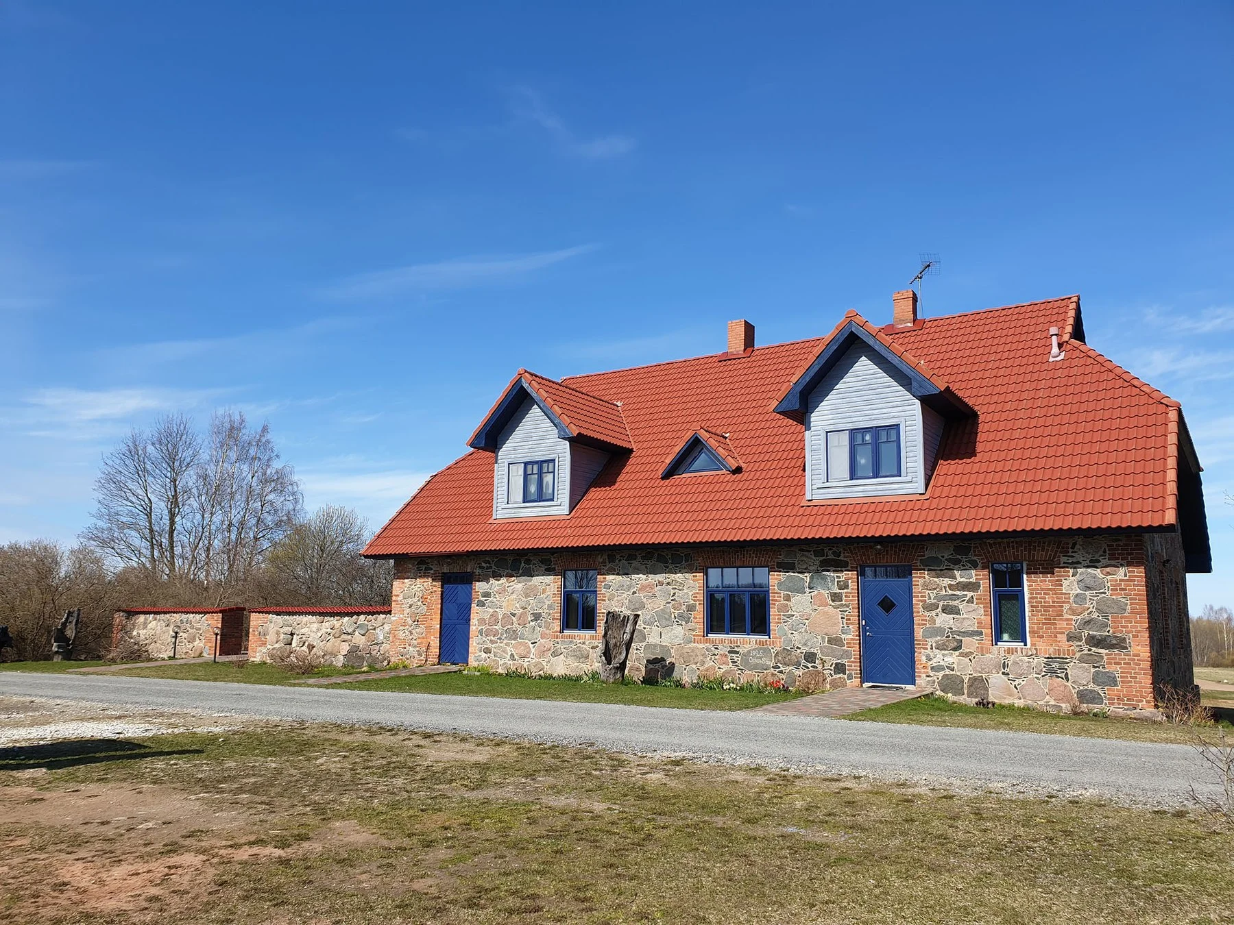 The fieldstone holiday house with its red roof in summer