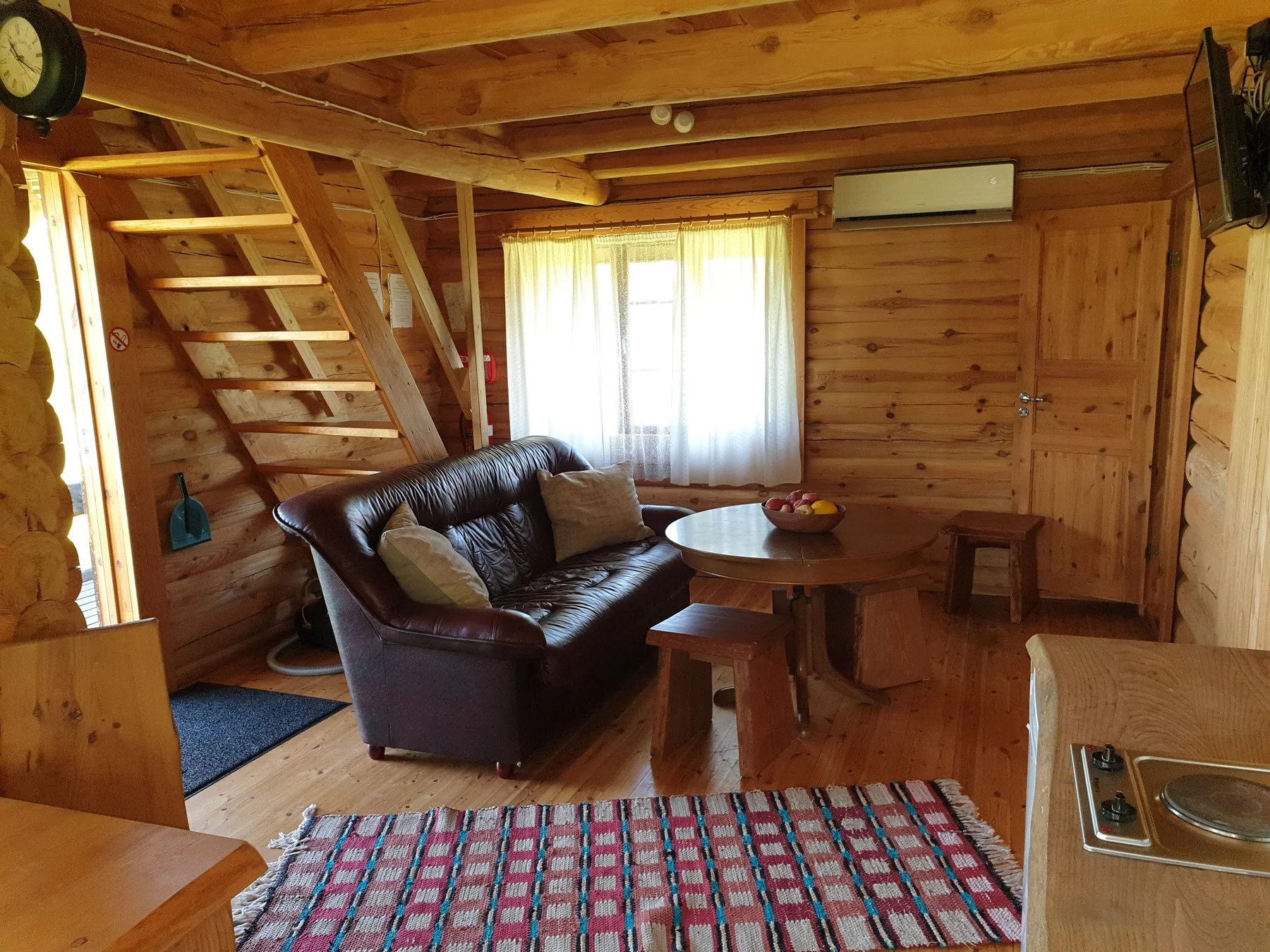Sauna house living room with a sofa, stairs and kitchenette