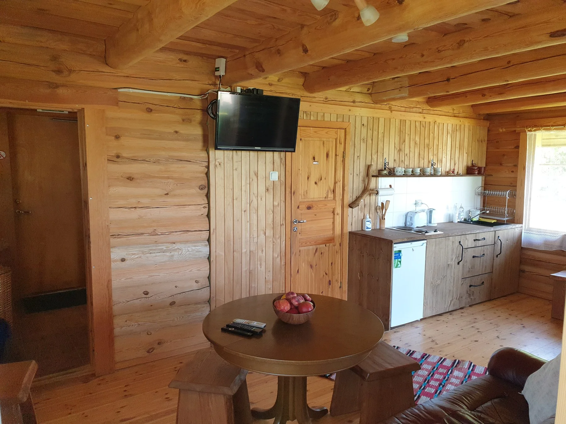 Living room with a TV, table and kitchenette
