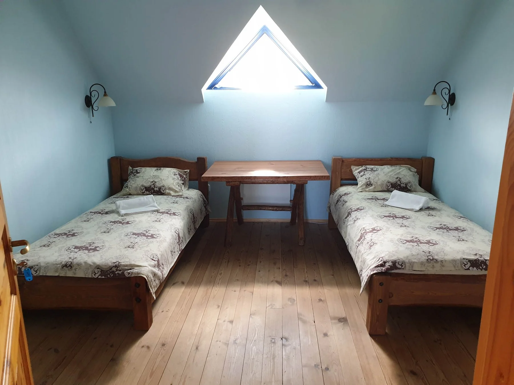 Two single beds under a triangular window